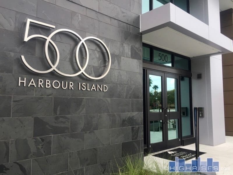 Modern building entrance with Harbour Island logo on stone wall.