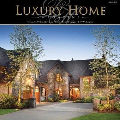 Elegant luxury home with warm lighting and lush landscaping at dusk.