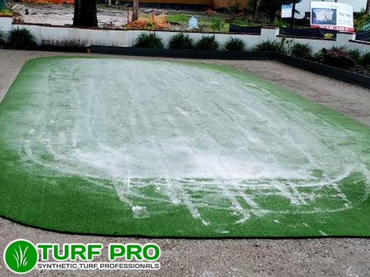 A golf putting green in poor condition with patchy turf and discoloration.
