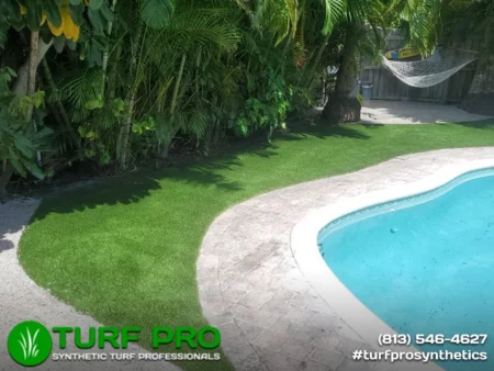 Great Reasons To Use Artificial Turf Around Your Pool A freshly edged lawn with a clean concrete pool border and clear blue water.