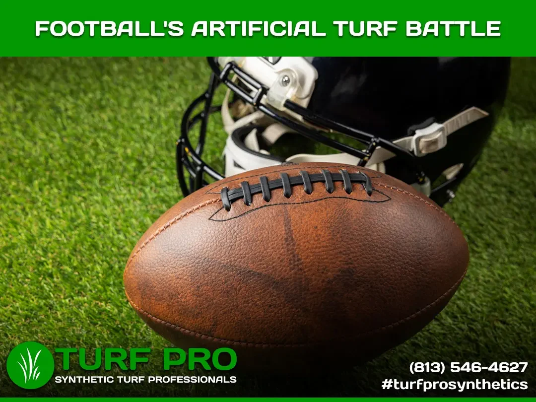 Close-up of a football on artificial turf with a helmet in the background.